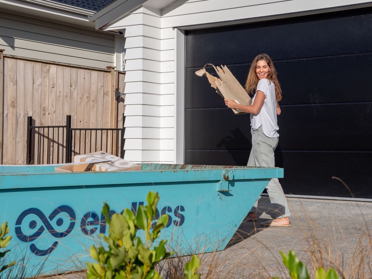 A woman using a skip bin to get rid of general waste