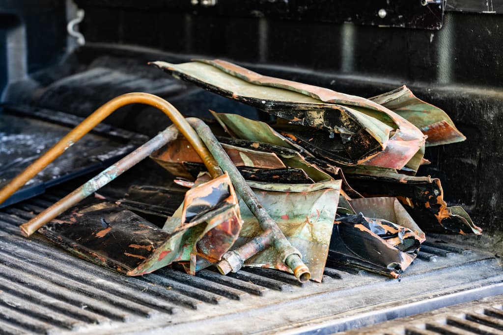 Pile of scrap copper in the back of a flatbed truck.